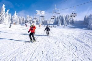 people enjoying skiing and snowboarding in mountain ski resort w